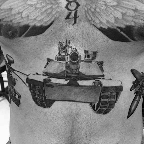 Black and grey tattoo of a modern tank centered on the lower torso, with realistic detailing and added missiles extending across the abs.