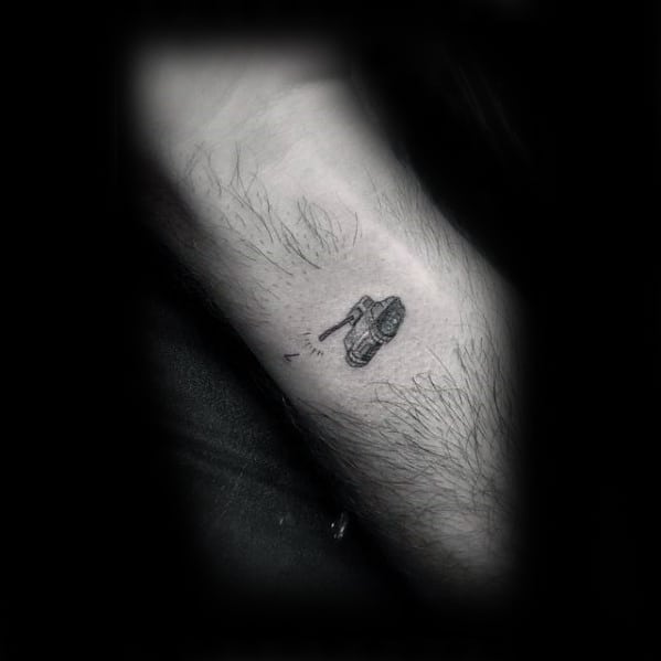 Tiny minimalist tank tattoo on the inner leg, featuring delicate linework and subtle shading for a discreet yet detailed design.