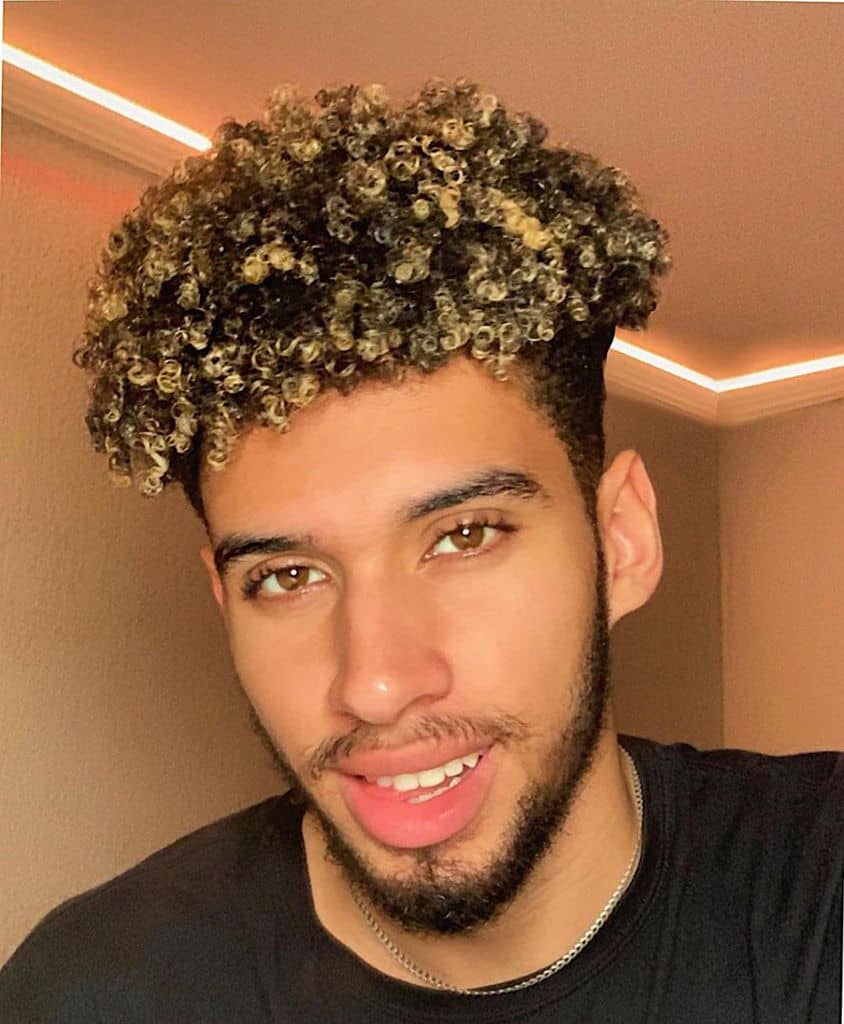 A black man with short type 3C curly hair matched with beard
