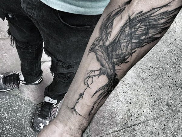 Forearm tattoo of a black bird in flight with abstract line styling