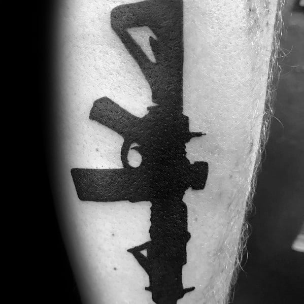 Bold black AR-15 silhouette tattoo on the forearm, featuring a minimalist yet striking design, symbolizing strength, precision, and firearm appreciation.