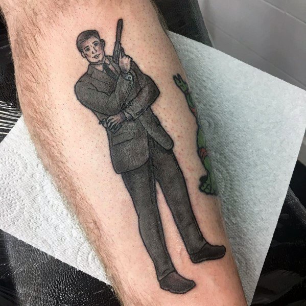 Black and grey Archer tattoo featuring the spy in a full-body pose, holding a gun with a confident smirk and clean shading.