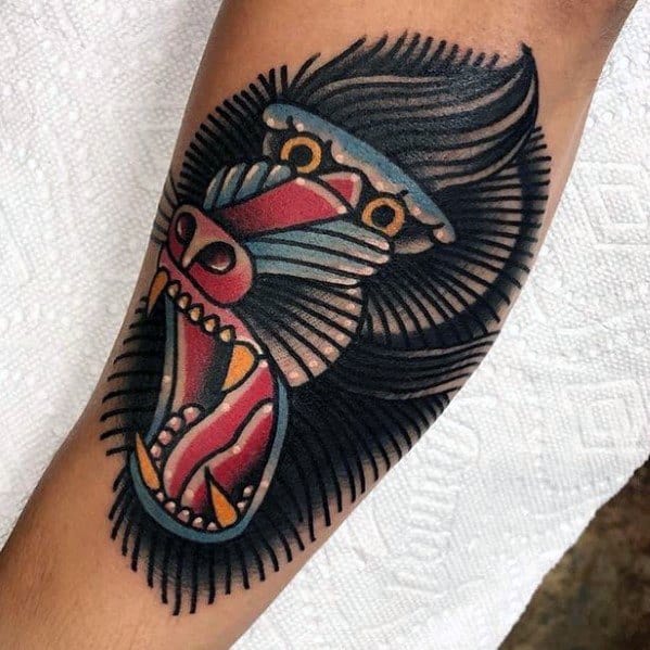 Neo-traditional baboon tattoo with bold outlines, vibrant colors, and a fierce open-mouthed expression, creating a striking and dynamic arm design.