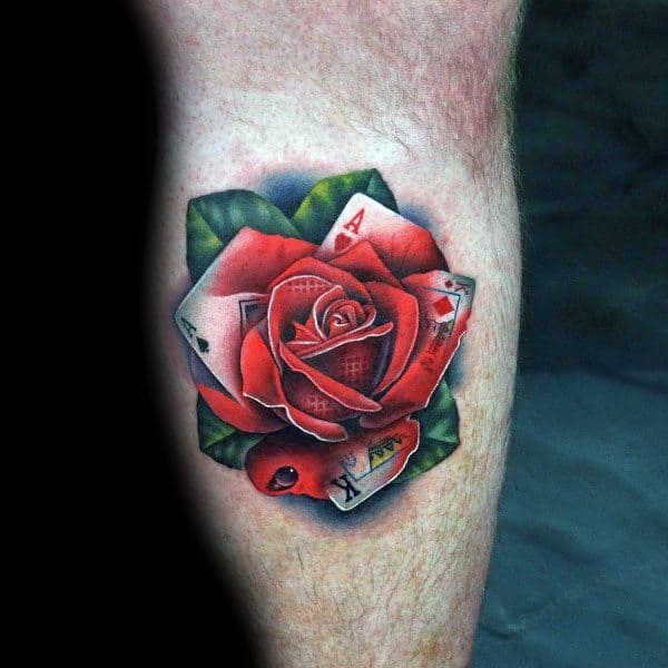 A stunning tattoo of a red rose elegantly unfurls on the person's arm, its petals intricately embedded with playing cards