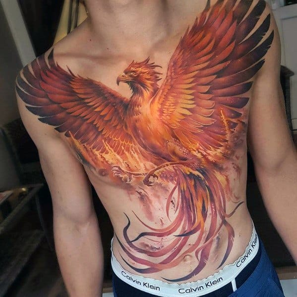Vibrant full-chest tattoo featuring a fiery phoenix with detailed feathers, dynamic shading, and intense orange and red tones for a powerful design.