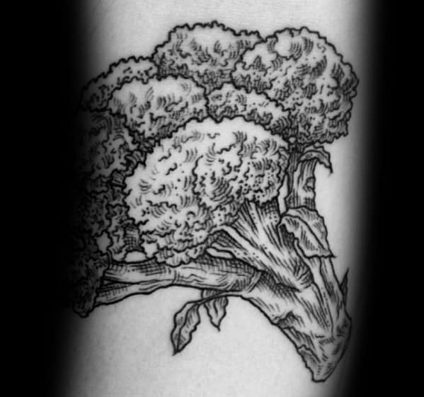 Detailed black ink broccoli tattoo with fine linework and shading, creating a realistic and textured botanical design.