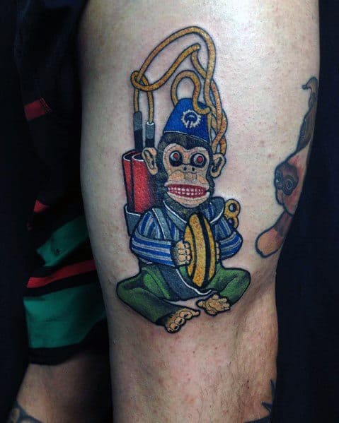 Colorful Call of Duty Monkey Bomb tattoo featuring bright details, cymbals, and explosives, capturing the iconic zombies weapon in a bold design.