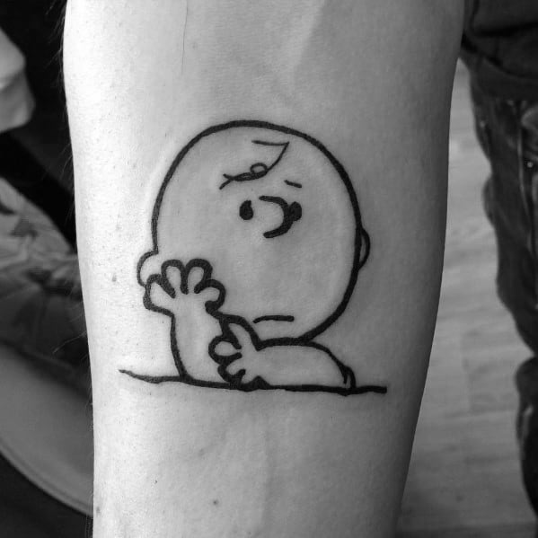 Minimalist black and white Charlie Brown tattoo featuring his classic worried expression, capturing nostalgia and Peanuts' timeless charm.