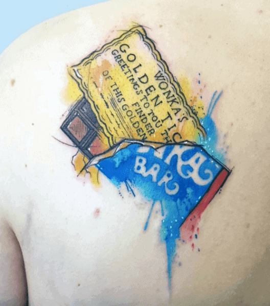 Colorful tattoo of a Wonka Bar with a Golden Ticket, designed in a watercolor style with splashes of blue and yellow on the upper back.