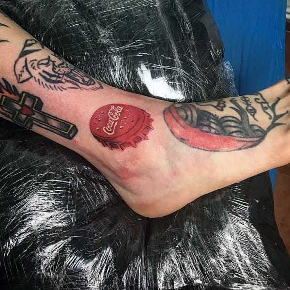 Hyper-realistic Coca-Cola bottle cap tattoo on the ankle, featuring detailed shading, highlights, and a 3D effect for a lifelike appearance.