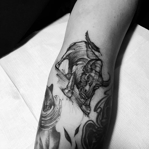 Sketch-style bull tattoo on the forearm, featuring dynamic motion lines and expressive shading for an artistic, hand-drawn look.