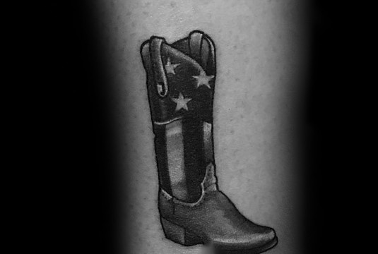 Black and white tattoo of a cowboy boot featuring an American flag design, symbolizing patriotism, Western culture, and rugged independence.