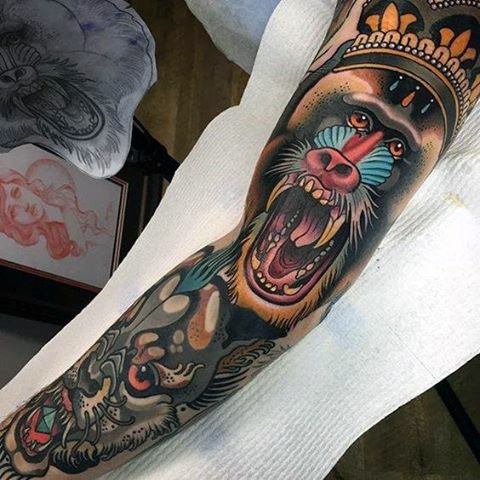 Neo-traditional baboon tattoo sleeve with bold colors, fierce expression, tribal details, and intricate shading for a dynamic and powerful design.