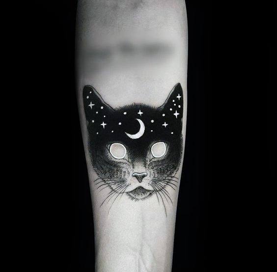 Blackwork mystical cat tattoo with glowing eyes, a crescent moon, and starry details, creating a celestial and eerie design.