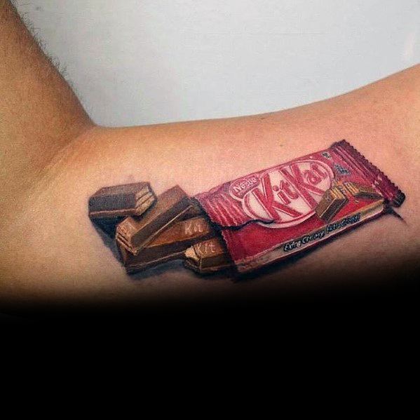 Realistic tattoo of an opened KitKat bar on the arm, featuring detailed shading and highlights to create a lifelike 3D effect.