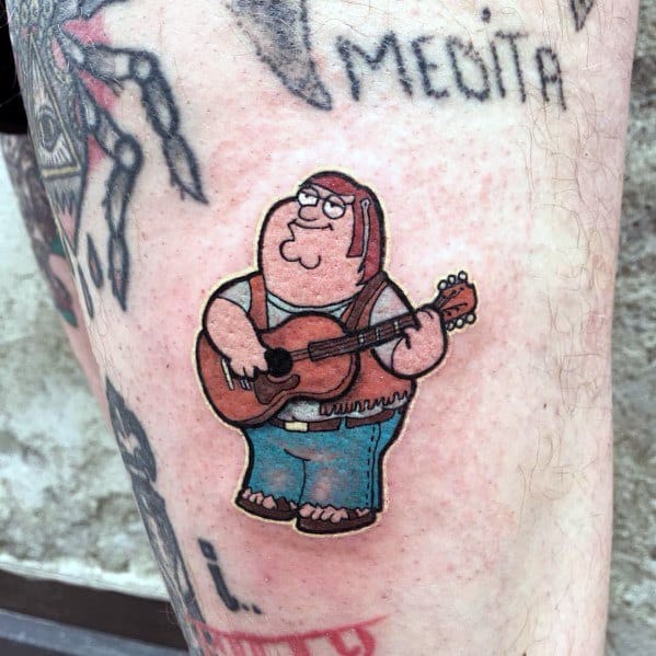 Tattoo of Peter Griffin from Family Guy dressed as a folk musician, wearing a fringe vest and jeans, playing an acoustic guitar with a relaxed expression.