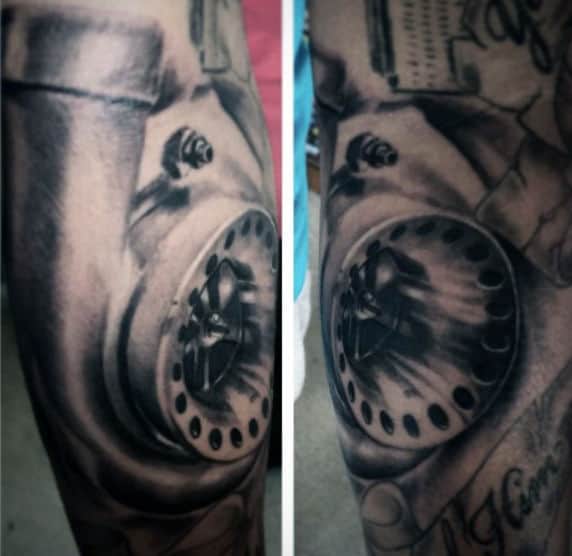 Close-up of a black and white tattoo covering an arm, featuring a detailed mechanical component with bolts and shading