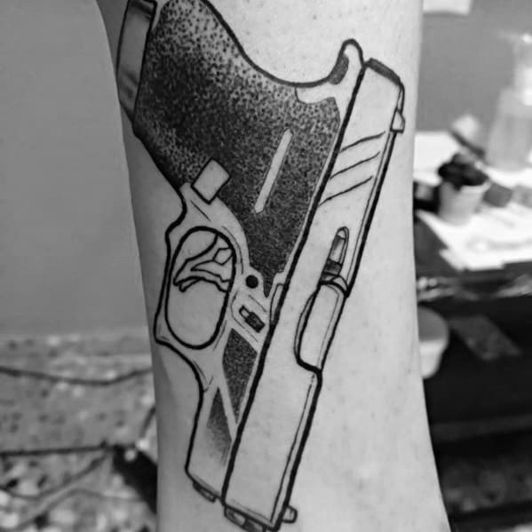 Black ink tattoo of a Glock pistol on the forearm, featuring bold outlines, dot shading, and a bullet chambered for a striking and detailed design.