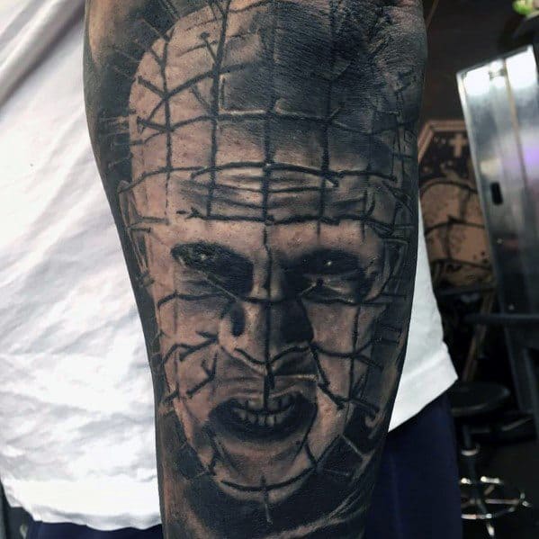 Black and grey *Hellraiser* tattoo of Pinhead with intense shading, deep shadows, and a menacing expression for a bold and eerie horror design.