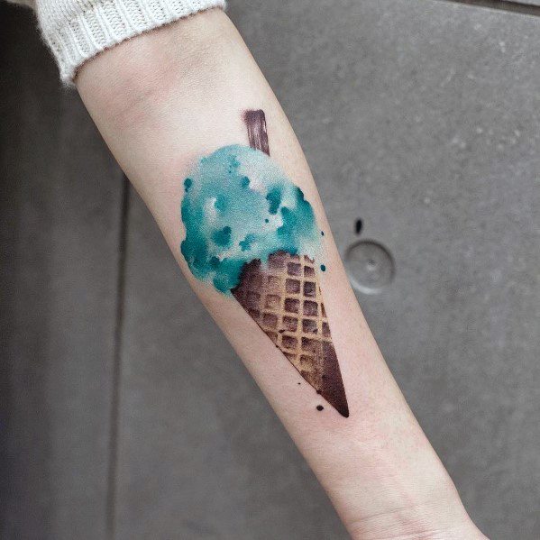 Watercolor-style tattoo of a mint chocolate chip ice cream cone with soft shading and a painterly effect, creating a delicate and artistic design.
