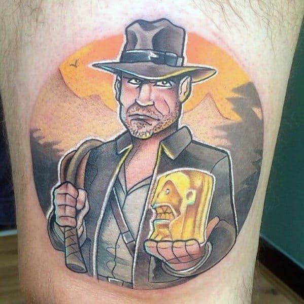 A colorful, cartoon-style tattoo of Indiana Jones holding the golden idol, with bold outlines and a vibrant mountain backdrop.