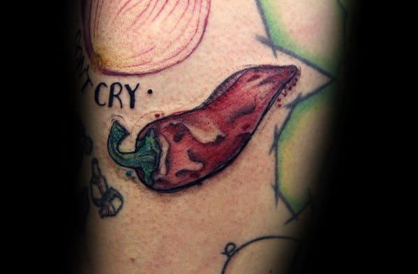 Realistic chili pepper tattoo with bold red shading and a green stem, featuring intricate details for a textured and vibrant design.