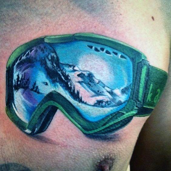 Tattoo of green ski goggles reflecting a snowy mountain landscape, capturing adventure and realism with vibrant colors and intricate details.