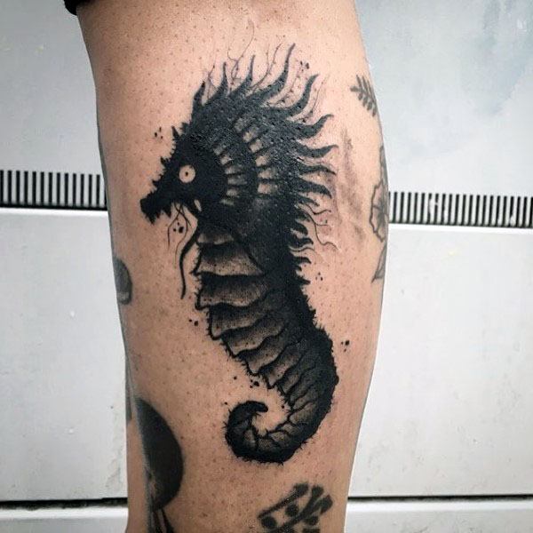 Blackwork seahorse tattoo on leg, featuring bold shading, high contrast, and a slightly rough texture for a dark and striking design.