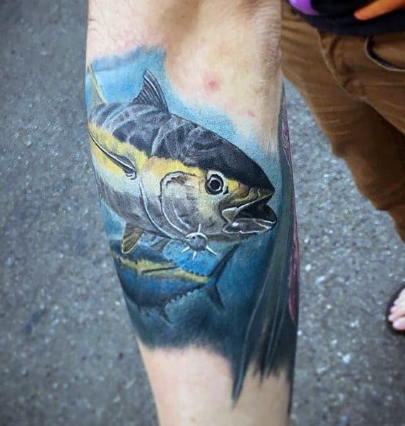 Hyper-realistic tuna fish tattoo on a man's forearm, featuring vibrant colors, intricate shading, and a deep blue ocean background for a lifelike design.