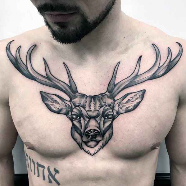 Black and grey elk tattoo on the chest, featuring bold antlers, fine linework, and intricate shading for a striking and symmetrical design.