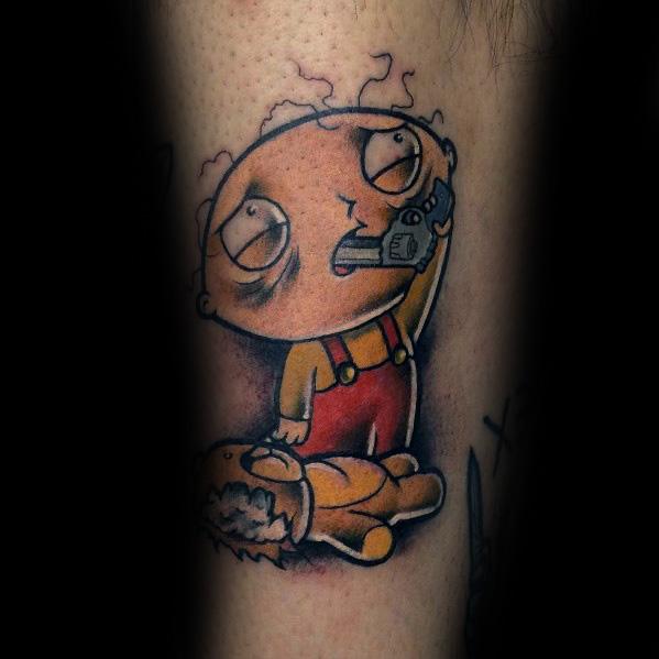 Tattoo of Stewie Griffin from *Family Guy* holding a gun to his head with a distressed look, while his damaged teddy bear lies on the ground.