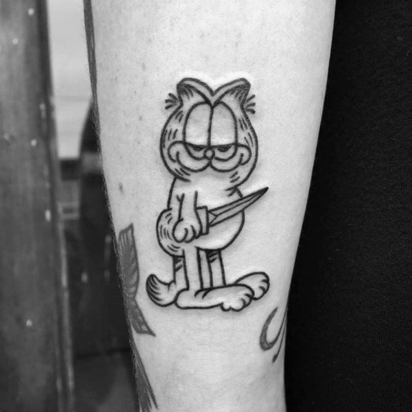 Black and gray Garfield tattoo with a smug look, holding a knife—bold and edgy design with a mischievous twist.