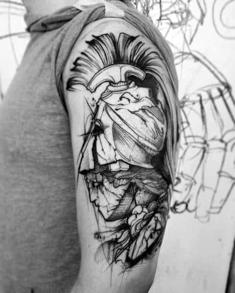 Sketch-style Athena tattoo on upper arm with dynamic lines, crested helmet, and abstract shading for an artistic, unfinished look