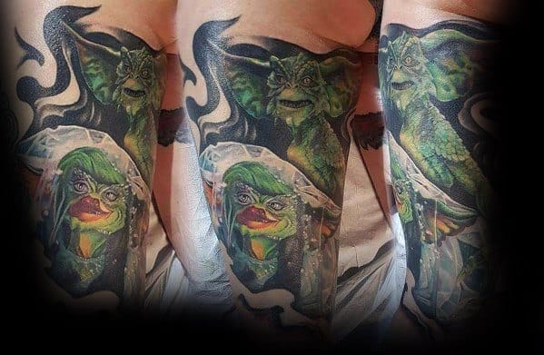 Gremlin tattoo sleeve featuring a detailed, eerie design with a sinister Gremlin and a mischievous, veiled female Gremlin in vivid colors.