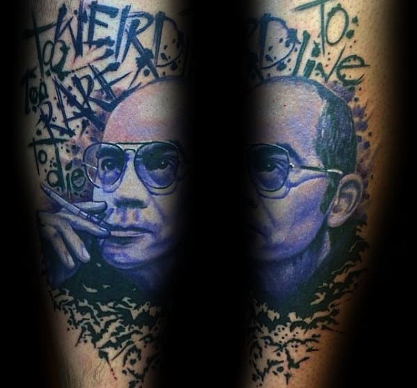 Detailed Hunter S. Thompson tattoo in a blue-toned style, featuring a realistic portrait with aviator glasses, a cigarette, and the quote "Too Weird to Live, Too Rare to Die."
