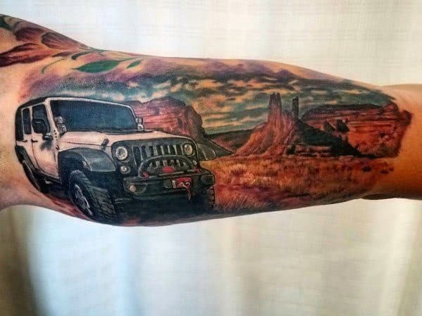 Vibrant tattoo of a white Jeep Wrangler set against a desert landscape with towering rock formations and a dramatic sunset sky, capturing an adventurous spirit.
