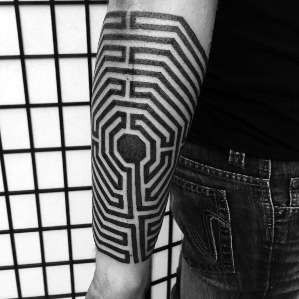 Bold blackwork labyrinth tattoo on a man's forearm, featuring an intricate geometric maze design with a central octagonal focal point.