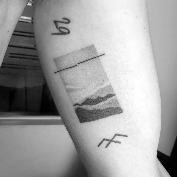 Abstract mountain tattoo on the arm, featuring layered dot-shaded peaks within a rectangular frame and minimalist symbols for a modern artistic design.