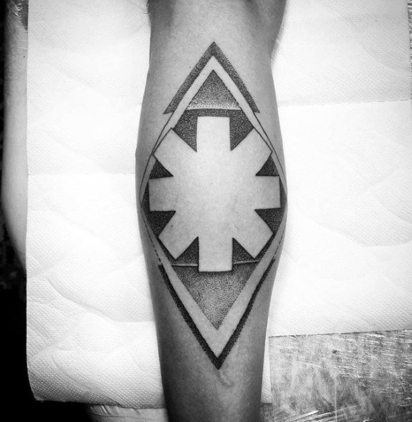 Calf tattoo featuring the Red Hot Chili Peppers logo inside a geometric diamond shape with detailed dotwork shading for a bold and modern look.