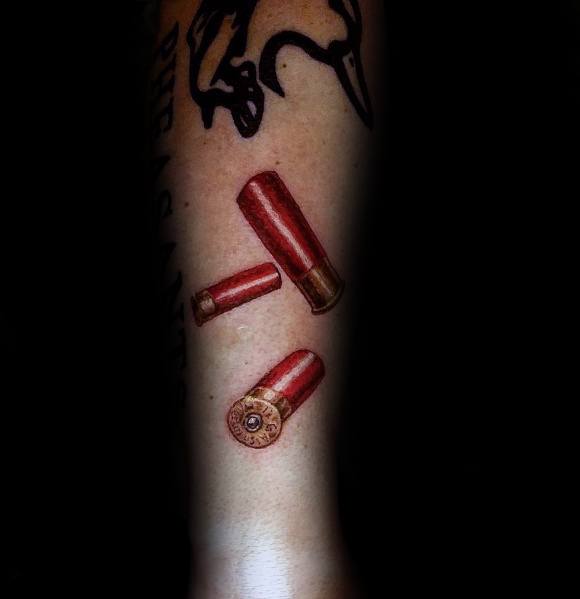 Realistic shotgun shell tattoo featuring three red and gold casings with fine shading and depth, creating a bold and dynamic design.