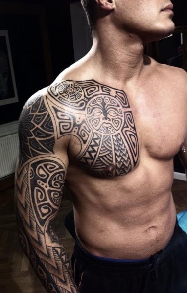 Man with intricate tribal tattoo covering chest, shoulder, and upper arm