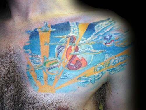 Colorful chest tattoo featuring a surreal sky scene with marbles floating among clouds and sun rays, creating a dreamlike and artistic design.