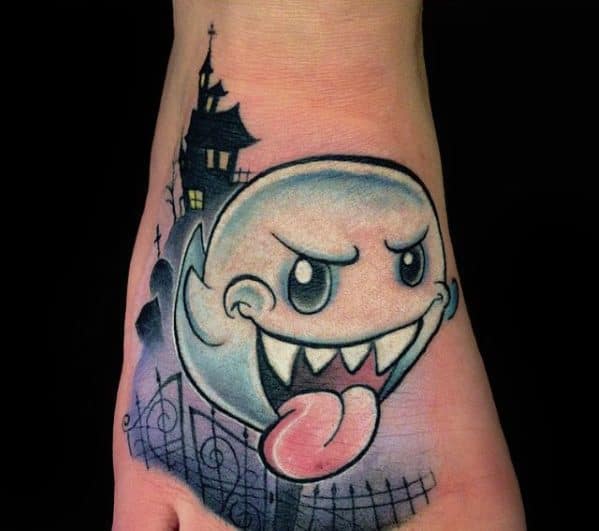 Mario ghost tattoo featuring Boo with a playful grin, tongue out, and a spooky haunted house background, inked with bold shading and eerie details.