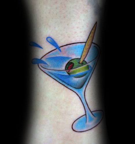 Vibrant martini glass tattoo with a blue liquid splash, an olive, and a toothpick. A bold and dynamic design with clean lines and bright colors.
