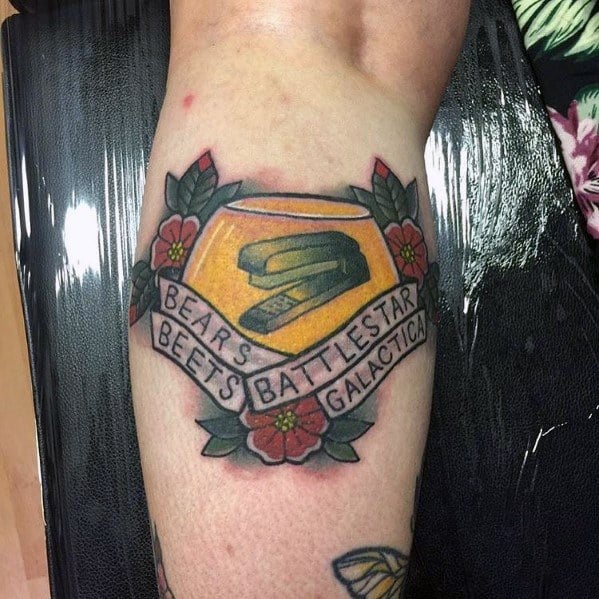 Color tattoo of a stapler encased in Jell-O, surrounded by flowers and a banner reading "Bears. Beets. Battlestar Galactica.," referencing Jim’s prank on Dwight from *The Office*.