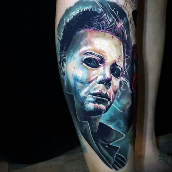 Vibrant Michael Myers tattoo with eerie blue lighting, capturing his sinister expression and haunting presence in a bold design.
