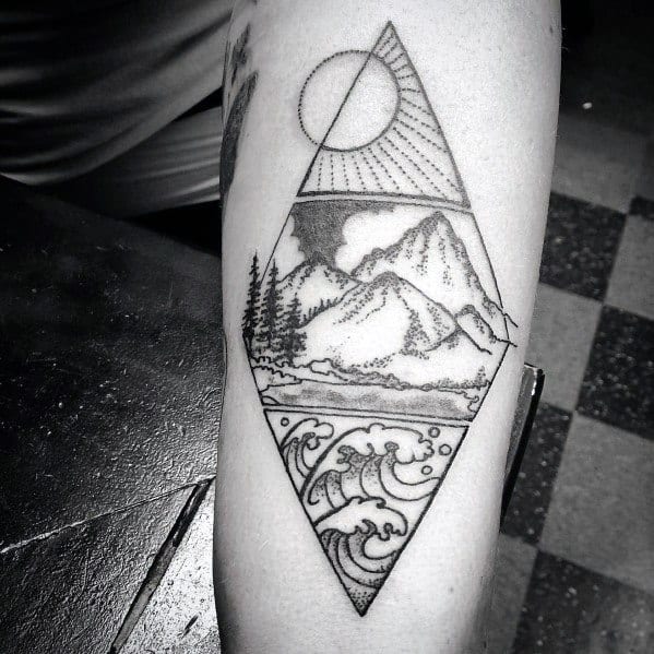Geometric black ink tattoo featuring mountains, waves, and a sun within a diamond-shaped frame, blending nature and symmetry in a bold design.