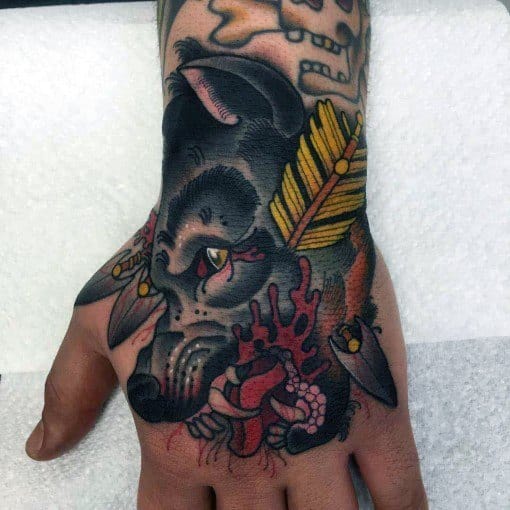 Neo-traditional hand tattoo of a wounded wolf with arrows, intense shading, blood details, and a bold color palette for a striking design.