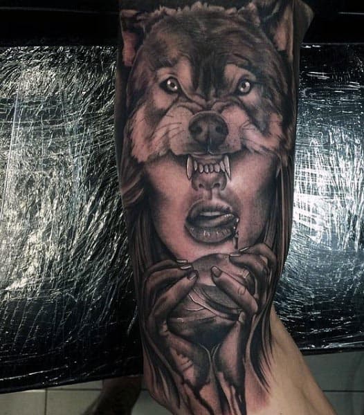 Black and grey surreal tattoo of a wolf merging with a woman's face, featuring intense shading and detailed realism for a bold design