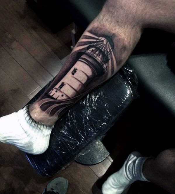 Leg tattoo of a lighthouse with light beams, person wearing white socks